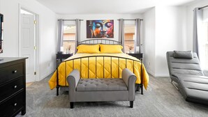 Una camera da letto con un letto, una panca, un divano e un quadro appeso al muro.