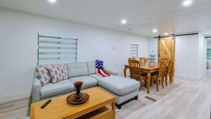 A modern living room with a grey sectional sofa, a wooden dining table with chairs, and a small wooden coffee table. - Vacation home ,silver springs, salt spring ,Ocala world equestrian center.  (Ocala)
