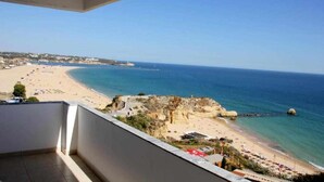 Un balcon avec vue sur une plage et la mer.