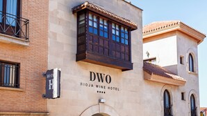 Une enseigne d’hôtel indiquant « DWO RIOJA WINE HOTEL » et une photo d’un balcon.