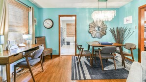 A dining area with a wooden table, chairs, and a chandelier.