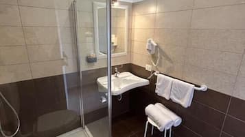 A modern bathroom with a glass-enclosed shower, a sink, and a toilet.