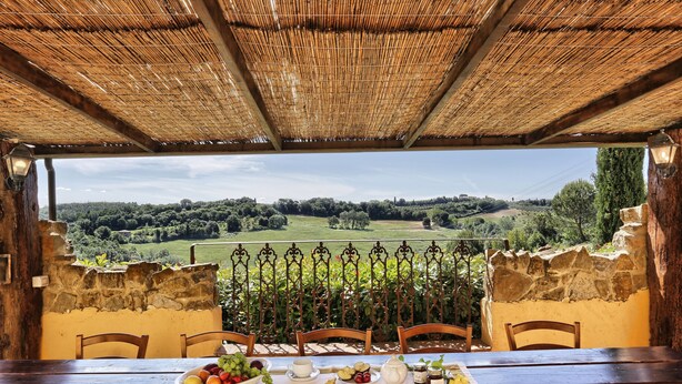 A dining table set with breakfast items, overlooking a lush green landscape.