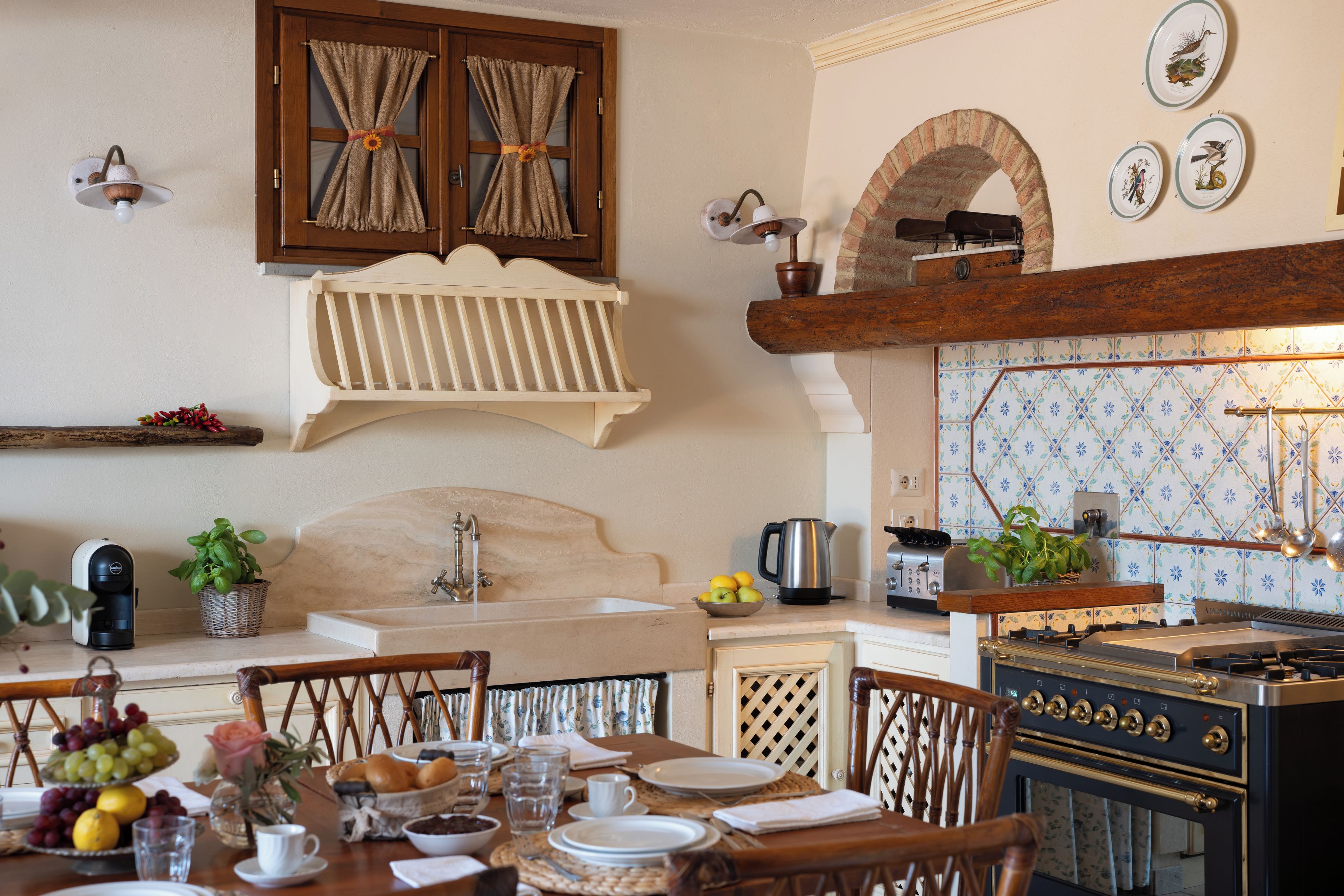 A kitchen with a wooden table set for dining, a sink, and a stove.