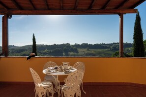 Une terrasse avec une table dressée pour deux personnes, offrant une vue imprenable sur un paysage magnifique.
