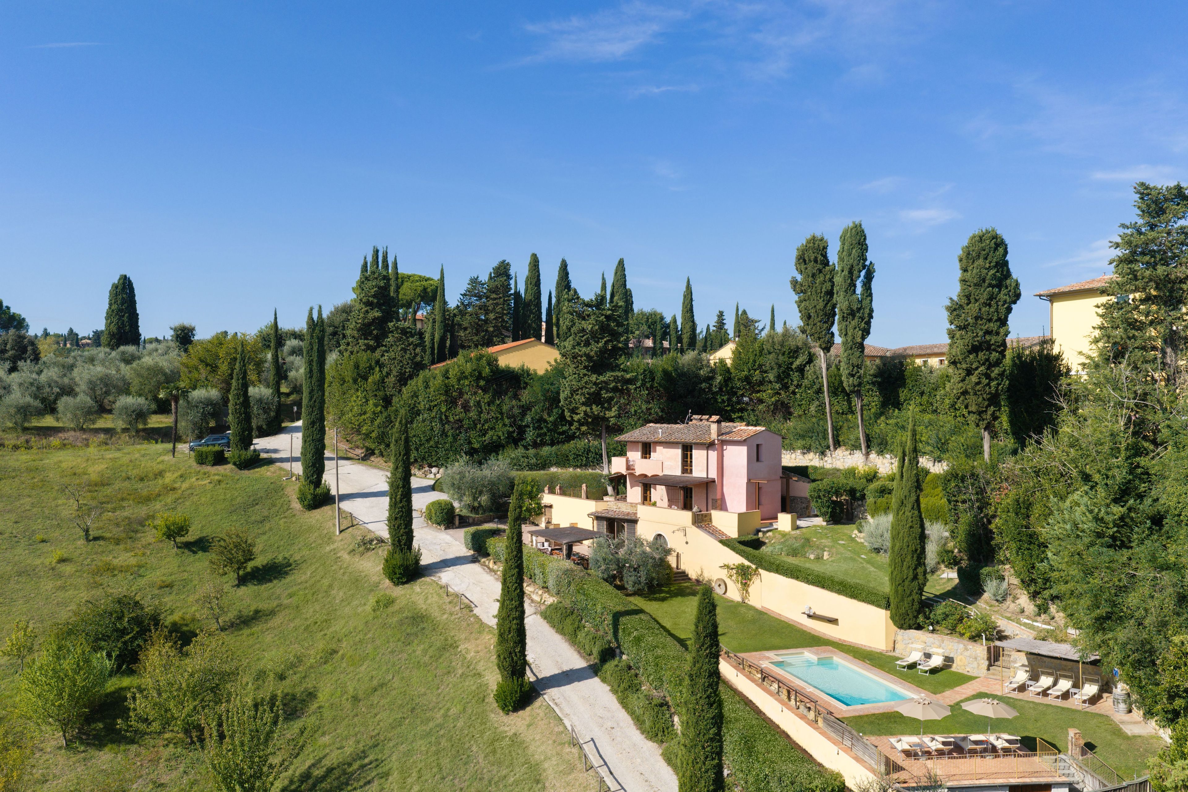 A residential property with a swimming pool, a garden, and a hillside view.