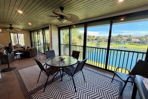 A spacious balcony with a view of a lake and palm trees, furnished with a round table and chairs. - VDL 75 - Relax and enjoy the tranquil lagoon in this 2nd floor condo. (Saint Augustine)