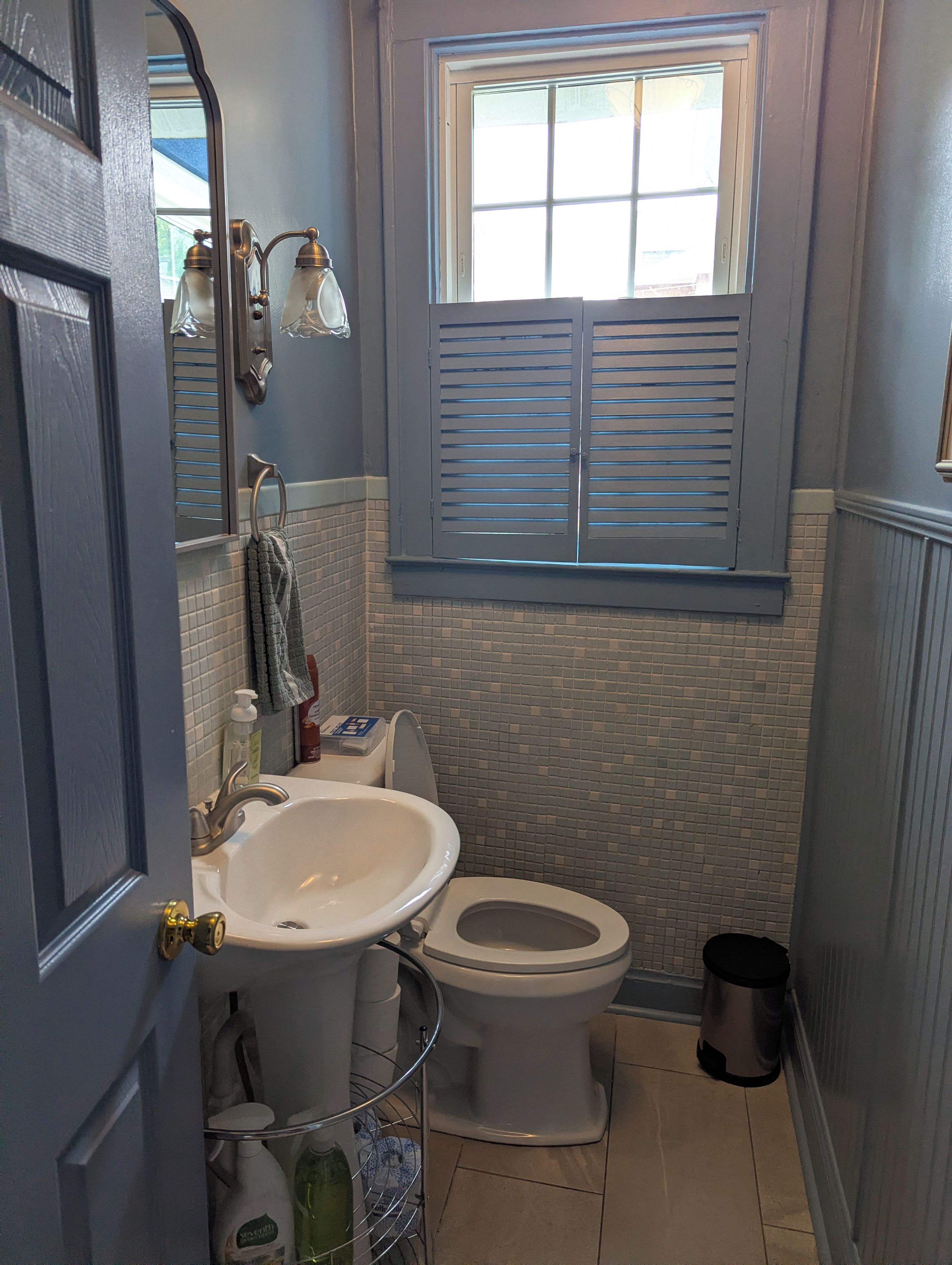 A bathroom with a sink, toilet, and window.