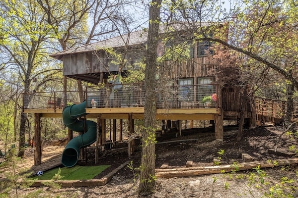 Your treehouse is in the middle of a forest and 15 feet off the ground! Check out that spiral slide!