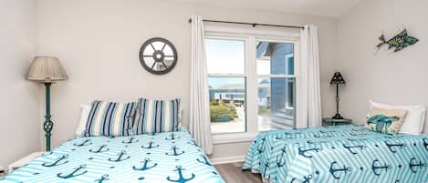 Quarto com duas camas, janela, relógio de parede e vista para o exterior.