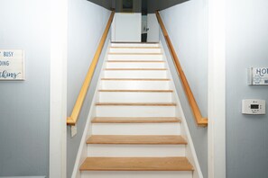 Eine Treppe mit Holzboden und Geländern, die zu einer oberen Etage führt.