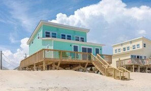 A two-story beach house with a wooden deck and a staircase leading to the upper level. - Duzzi's Destiny - Oceanfront 5 BR Cottage!  Dog Friendly! (Surf City)