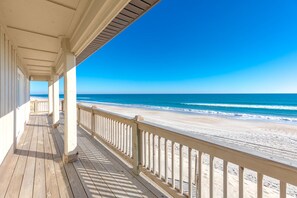 A wooden deck with a railing overlooking a beach. - Sandy Toes - Enormous 5BR Oceanfront Home with Apartment (Surf City)