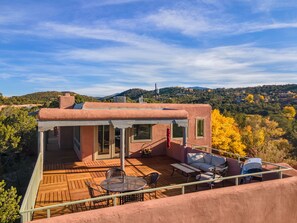 A rooftop terrace with a wooden deck, outdoor furniture, and a view of the surrounding landscape. - New! Eastside Overlook Retreat with Roof Top Deck - 7 Mins to Santa Fe Plaza (Santa Fe)