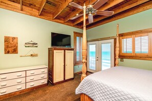 A bedroom with a four-poster bed, a ceiling fan, a television, and a wooden cabinet. - Barefoot Shack - Classic Custom 5BR Oceanfront Home - Great Views from Decks (Surf City)