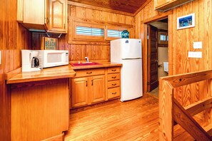 A compact kitchen with wooden cabinetry, a white refrigerator, a microwave, and a coffee maker. - Barefoot Shack - Classic Custom 5BR Oceanfront Home - Great Views from Decks (Surf City)