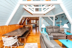 Une pièce de style loft avec une table à manger en bois, un canapé et une chaise.
