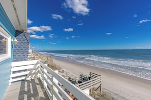 A beach view from a balcony with a wooden deck, overlooking the ocean. - Barefoot Shack - Classic Custom 5BR Oceanfront Home - Great Views from Decks (Surf City)