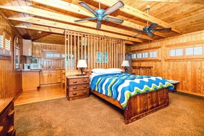 A wooden interior with a bed, nightstands, a lamp, and a ceiling fan. - Barefoot Shack - Classic Custom 5BR Oceanfront Home - Great Views from Decks (Surf City)
