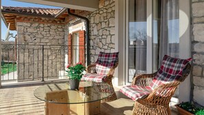 A balcony with wicker chairs, a glass table, and a potted plant. - Gorgeous home in Nedescina (Nedescina)