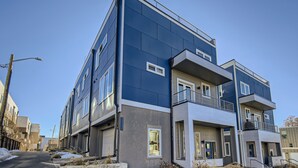 A modern multi-story building with balconies, large windows, and a clear sky. - Modern Townhouse - Walkable to Mile High Stadium - Rooftop Views with Firepit (Denver)