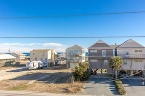 A coastal residential area with houses, a trailer, and a clear view of the ocean.