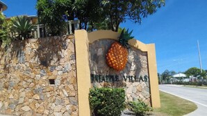 Eine Steinsäule mit einer Ananas und dem Schriftzug "Pineapple Villas".