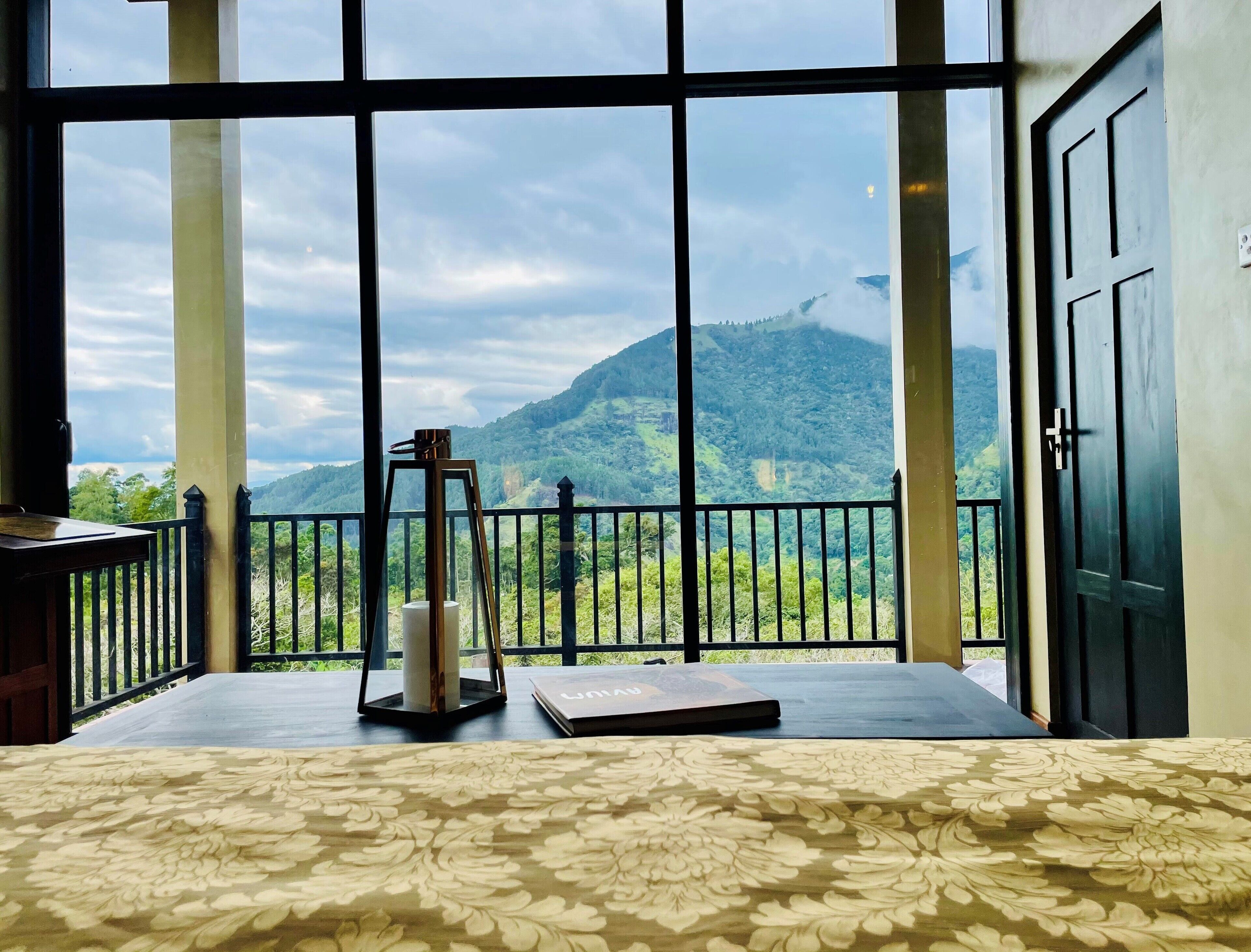A room with a large window offering a view of a mountainous landscape.