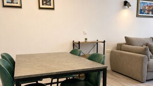 Un coin repas avec une table et des chaises, un canapé et deux tableaux encadrés au mur.