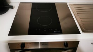 A kitchen with a black induction cooktop, a built-in oven, and a microwave. - B&BO - IN BOLOGNA YOU DREAM - APARTMENT - FREE PARKING  (BOLOGNA)