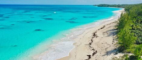 Una playa con aguas turquesas cristalinas y una orilla arenosa.
