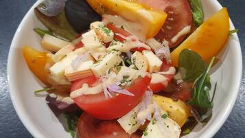 Un tazón de ensalada con diferentes verduras y queso.