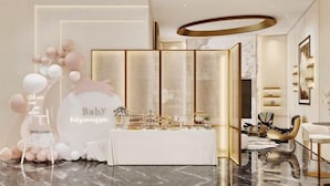 Decoración para una fiesta de bienvenida al bebé, con un cartel que dice 'Baby', globos y una mesa con bocadillos.