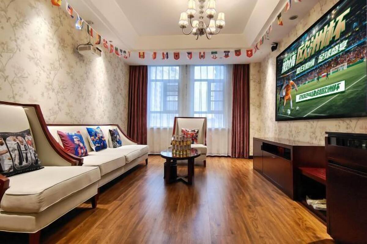 Ein Wohnzimmer mit einer Couch, einem Couchtisch und einem an der Wand montierten Fernseher.