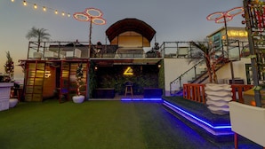 A modern building with a balcony, artificial grass, and decorative lighting. - Treebo C1 Taj Nirvana (Agra)