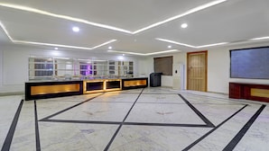 A hotel lobby with a marble floor, a reception desk, and a large screen. - Treebo C1 Taj Nirvana (Agra)
