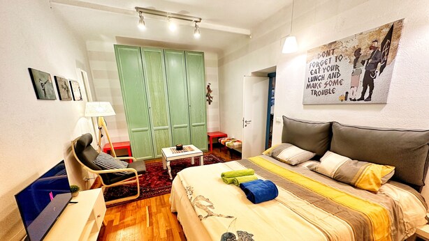 A hotel room with a bed, a desk, a chair, a wardrobe, and a painting on the wall. - Meizon Genoa - 5 minutes from the station, the sea, the subway (Genova)