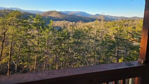 A wooden deck with a view of a forested mountain range. - STUNNING SMOKY MOUNTAIN VIEWS! Hot Tub! Games! Close to Dollywood and Parkway! (Sevierville)