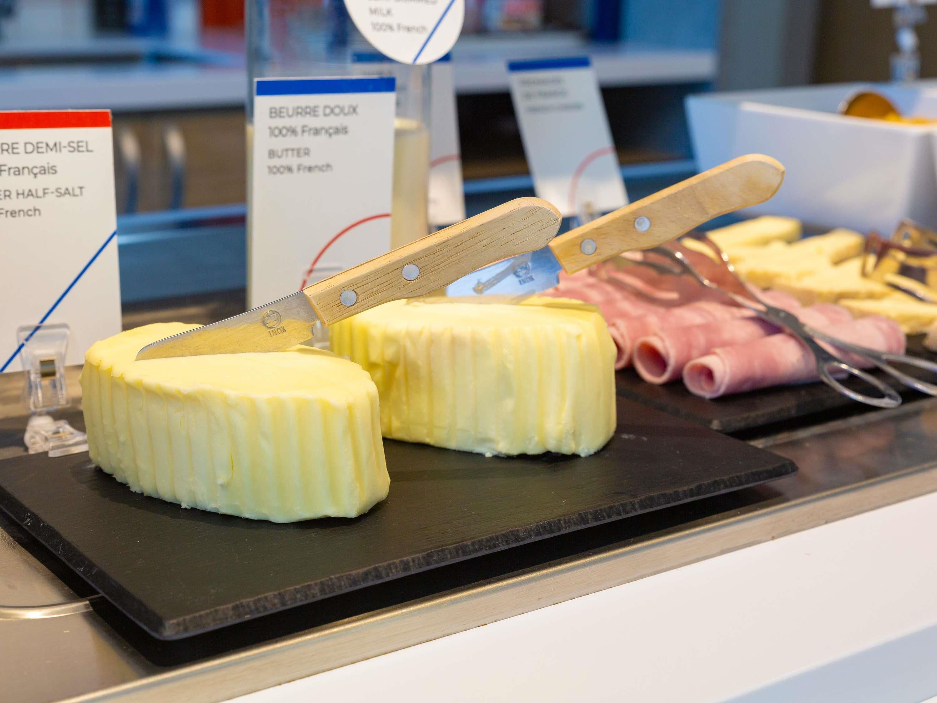 Exhibición de diversos productos lácteos, como mantequilla y queso, con etiquetas que indican origen francés.