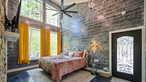 A bedroom with a bed, a ceiling fan, and a large window with curtains. - Butterfly Kisses- Perfect Honeymoon Cabin! (Broken Bow)