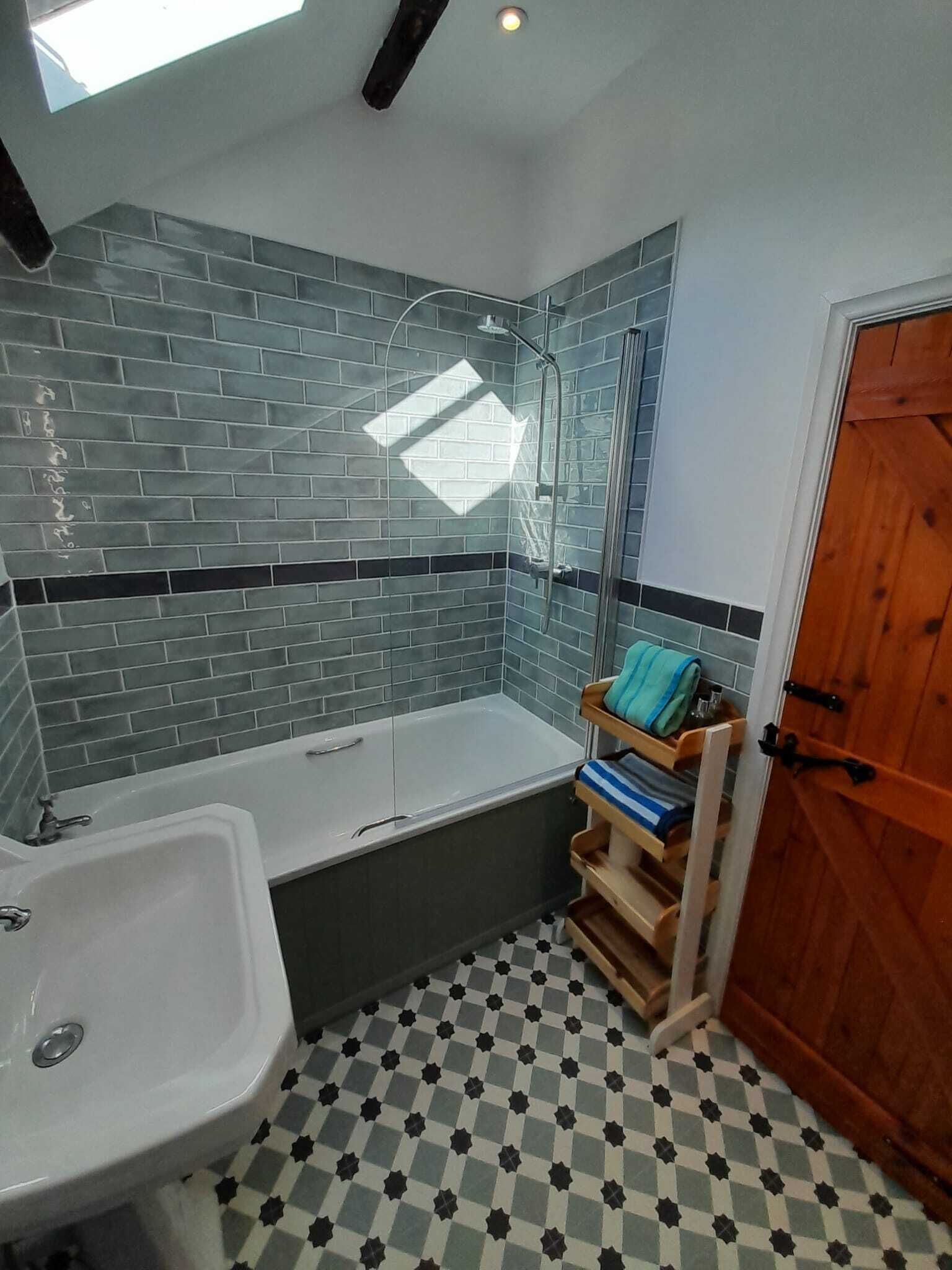 A bathroom with a bathtub, a sink, and a shower area.