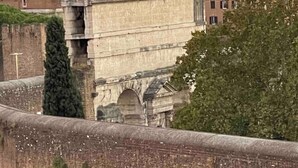 A stone bridge with multiple arches, a stone building with classical architecture, and a tree in the foreground. - Loft SanLorenzo (Roma)