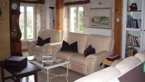 A cozy living room with a beige sofa, a small coffee table, and a bookshelf.