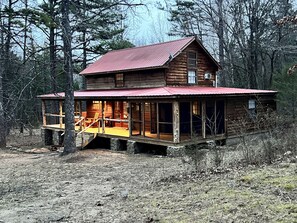 A rustic cabin with a porch and a covered deck, surrounded by trees. - Mountain View Creekside Cabin on 12 Acres. (Mountain View)