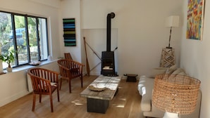 A living room with a fireplace, wooden furniture, a sofa, and a lamp.