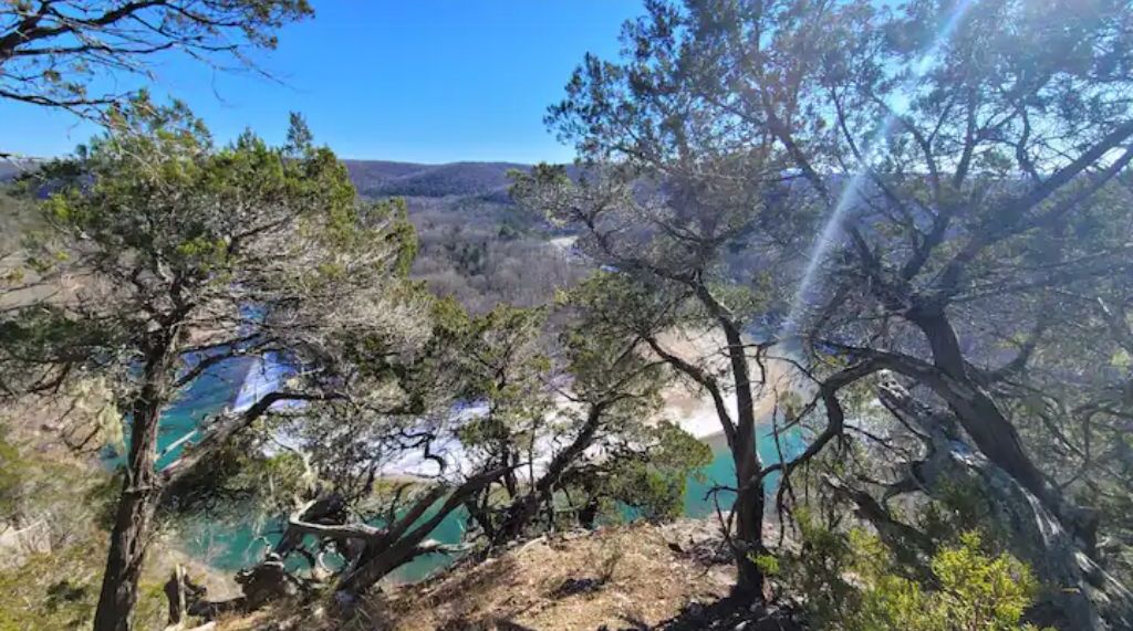 A mountainous landscape with trees and a clear blue sky.