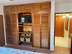 Features a wardrobe with multiple compartments and a comfortable bed with a headboard.