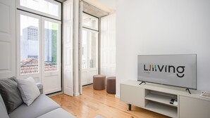 Un salon moderne avec un grand téléviseur à écran plat, un canapé et une table basse.