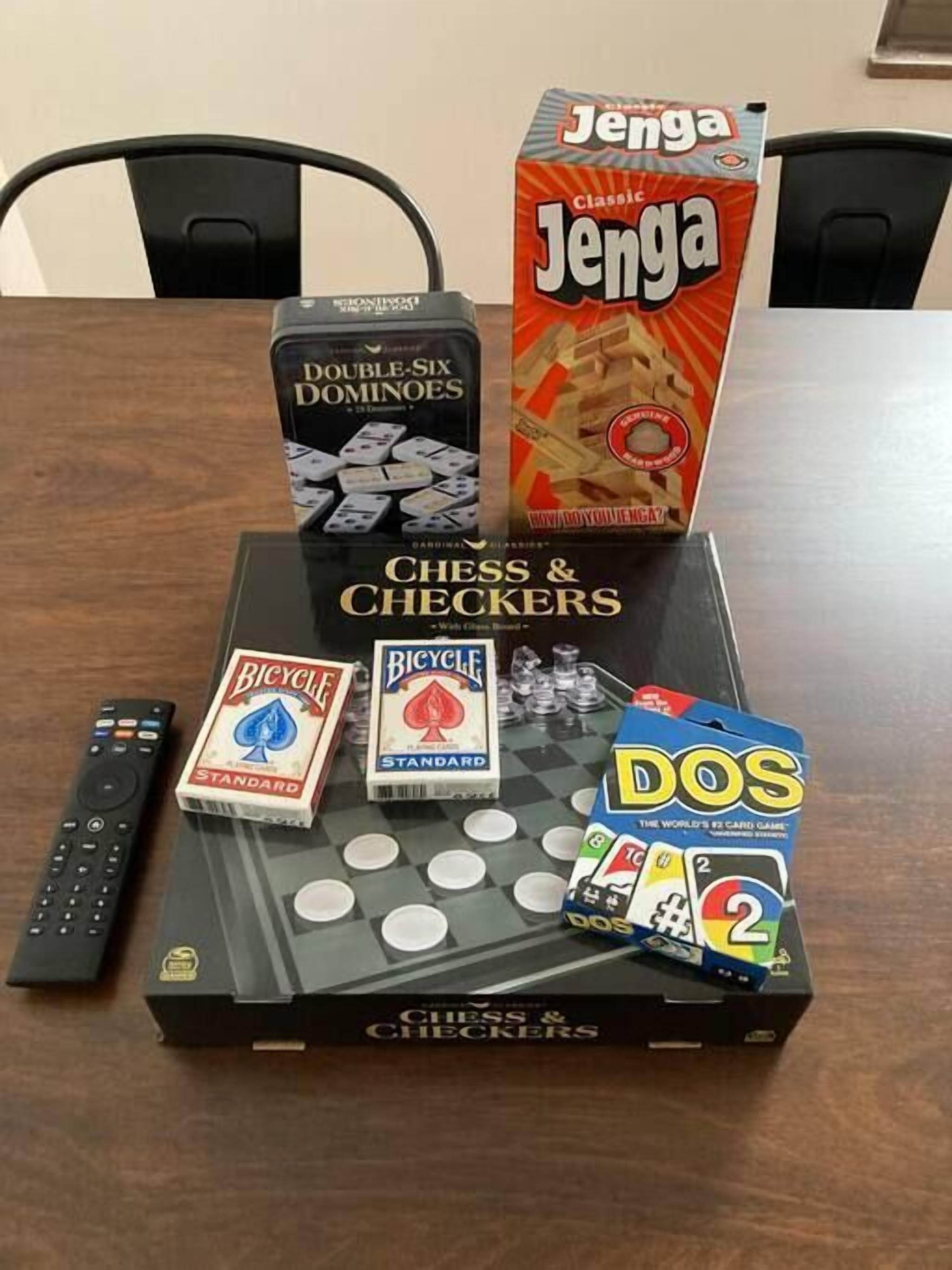 A table with various board games including Jenga, Double-Six Dominoes, Bicycle, and Chess & Checkers.
