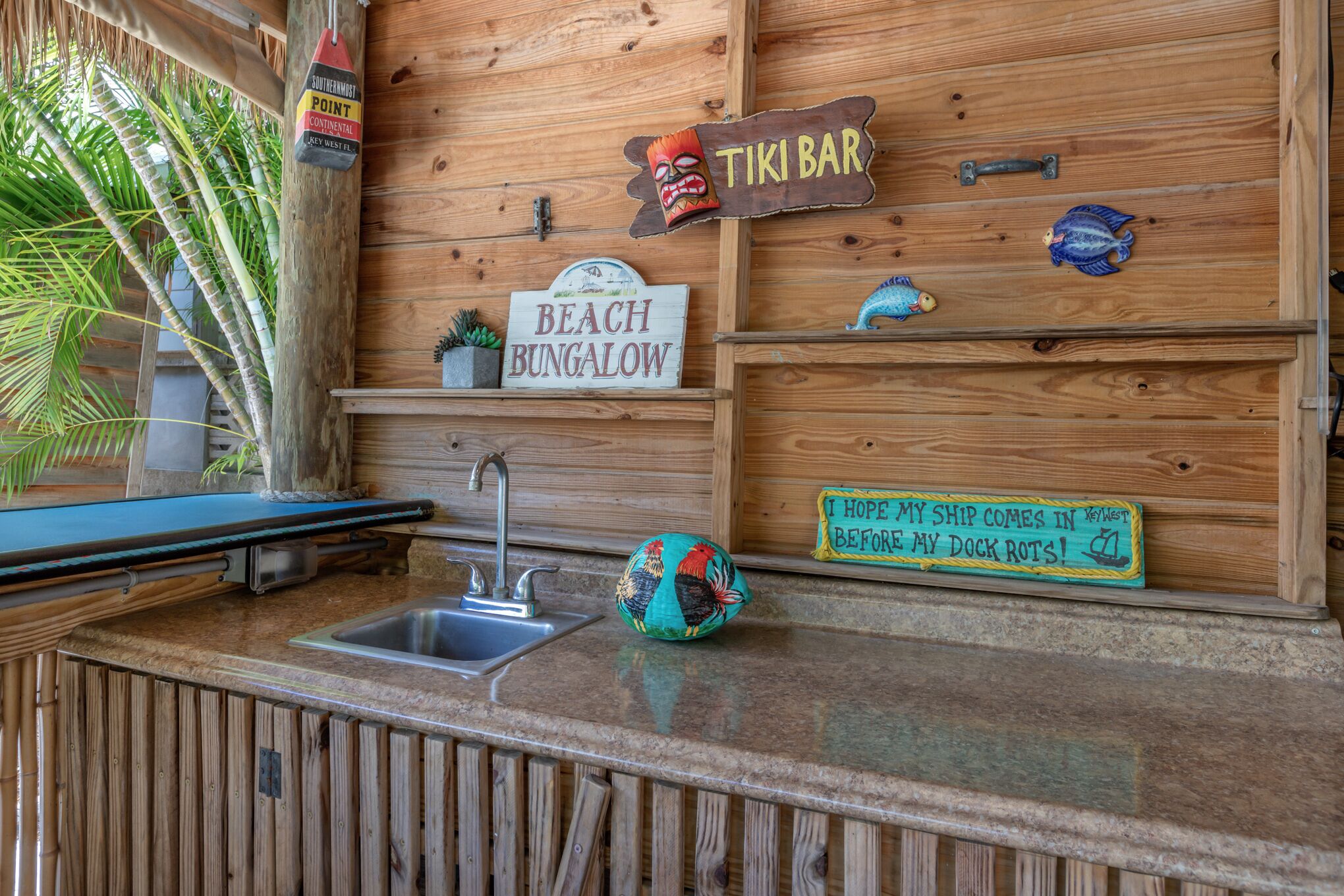 A wooden bar area with a sign for 'TIKI BAR' and 'BEACH BUNGALOW'.